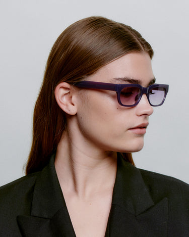 Lilla firkantet A.Kjærbede solbriller, lilla glas, fra siden på dame