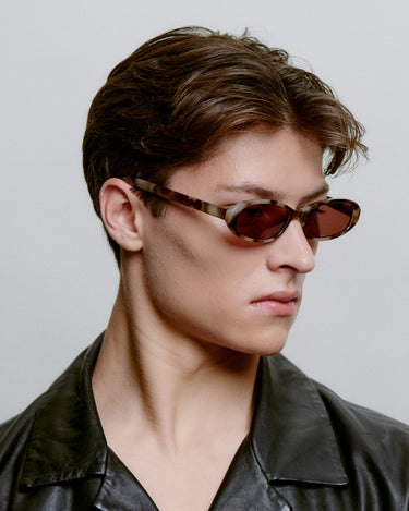 Ovale brune A.Kjærbede solbriller med mørk linse - fra siden på herremodel