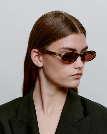 Ovale brune A.Kjærbede solbriller med mørk linse - fra siden kvindemodel