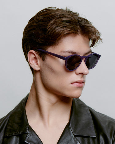 Runde lilla A.Kjærbede solbriller med mørk linse fra siden på herremodel