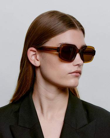 Store brune firkantet A.Kjærbede solbriller med mørk glas - side profil af dame