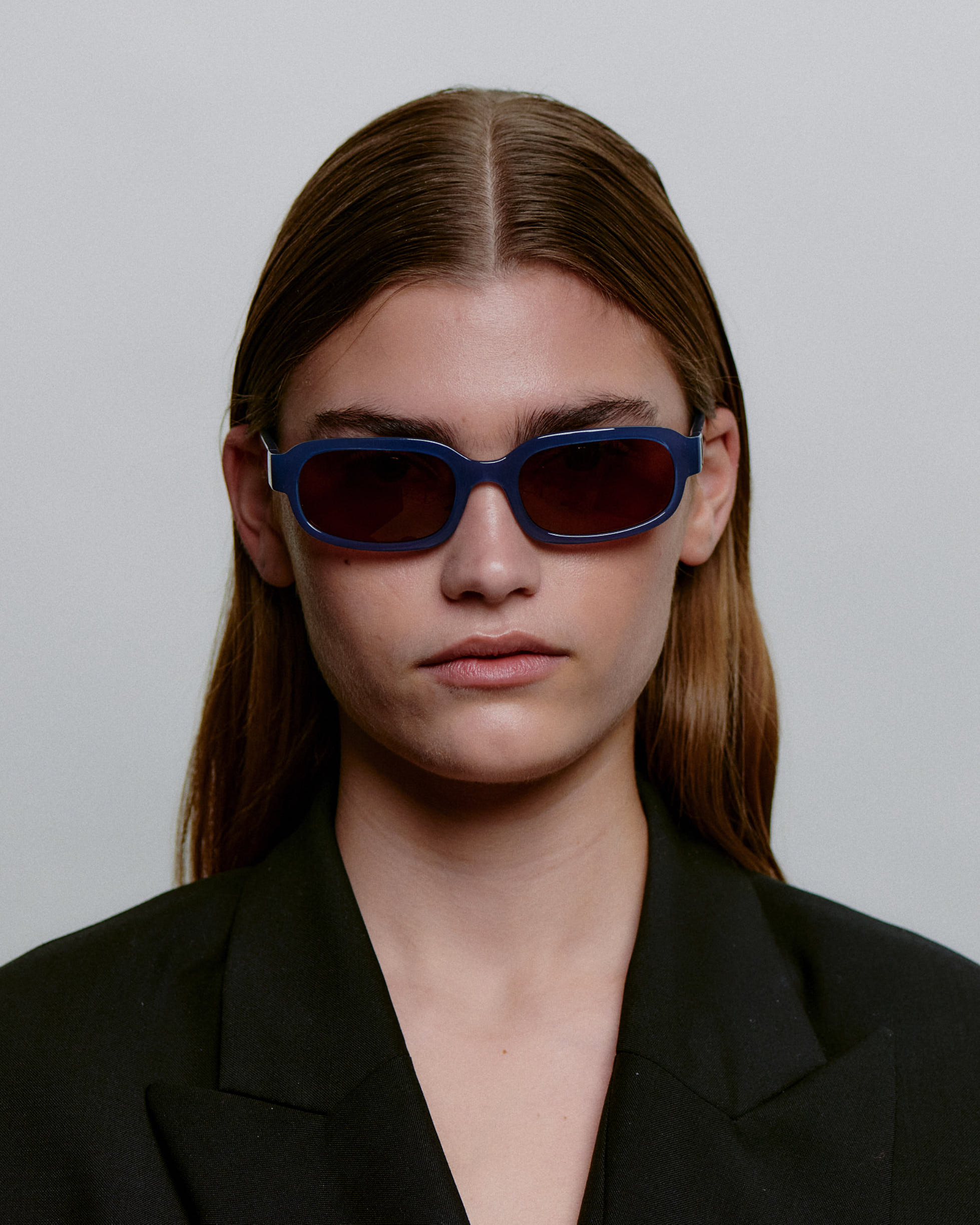 Blå firkantet A.Kjærbede solbriller med mørk glas - foran på kvindemodel