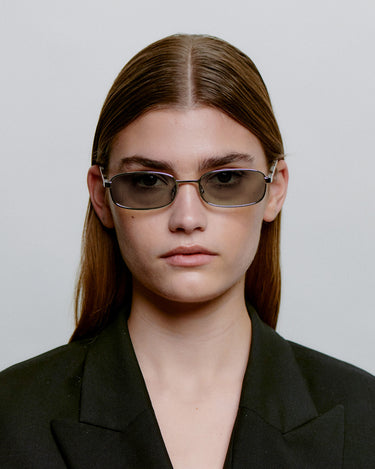 Sølv A.Kjærbede metal solbriller med mørk glas foran på kvindemodel